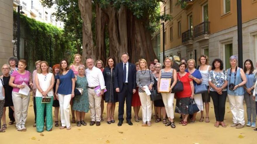 Representantes de colectivos feministas y diputadas de Podemos y PSPV, con Puig en las Corts.