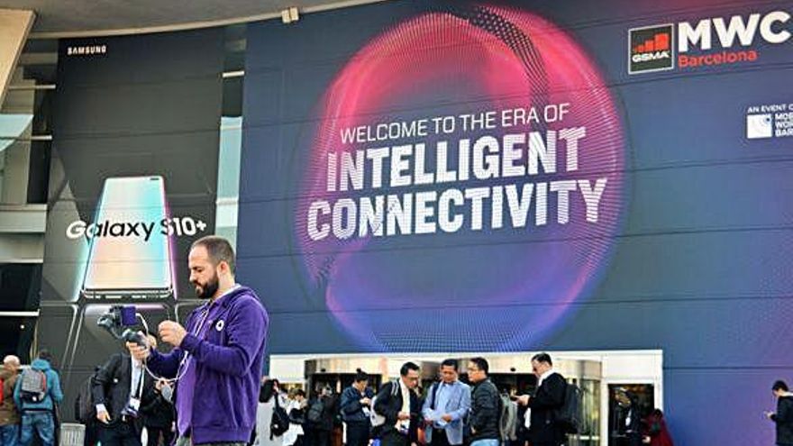 Un noi amb un equip de gravació mòbil davant de l&#039;entrada del MWC 2019