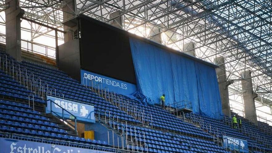 Operarios descubriendo en la mañana de ayer los videomarcadores, que hoy ya estarán funcionando.