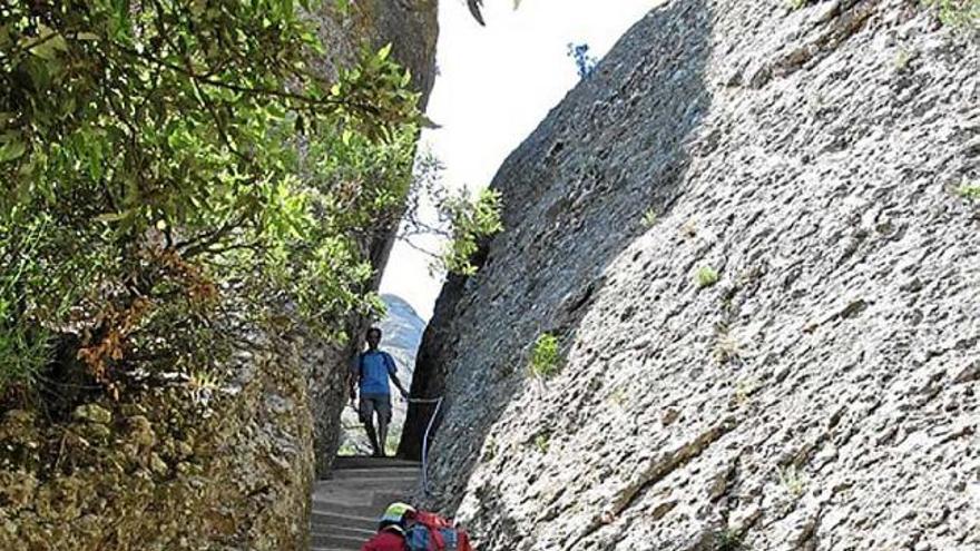 Uns excursionistes pujant pel Pas dels Francesos, camí de Sant Jeroni