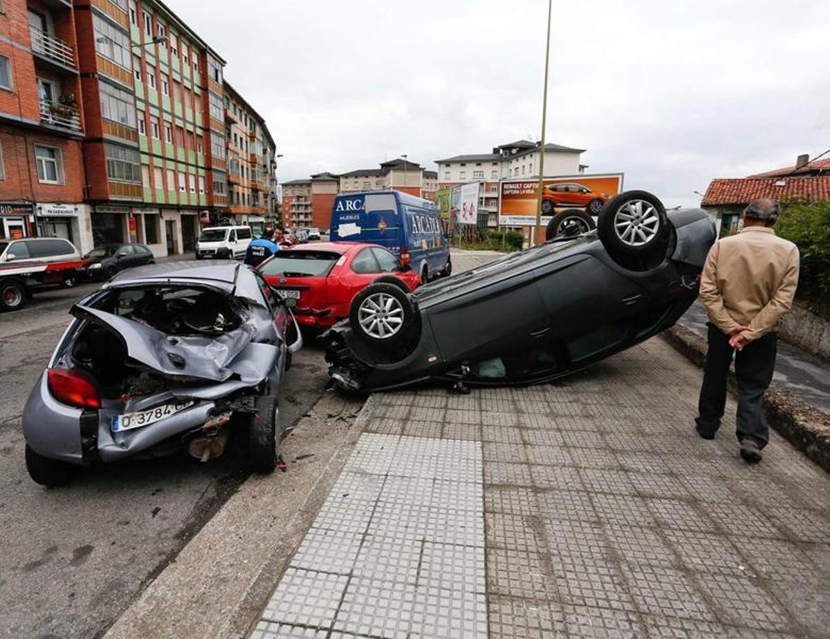 Una conductora, herida leve tras chocar contra tres coches y volcar