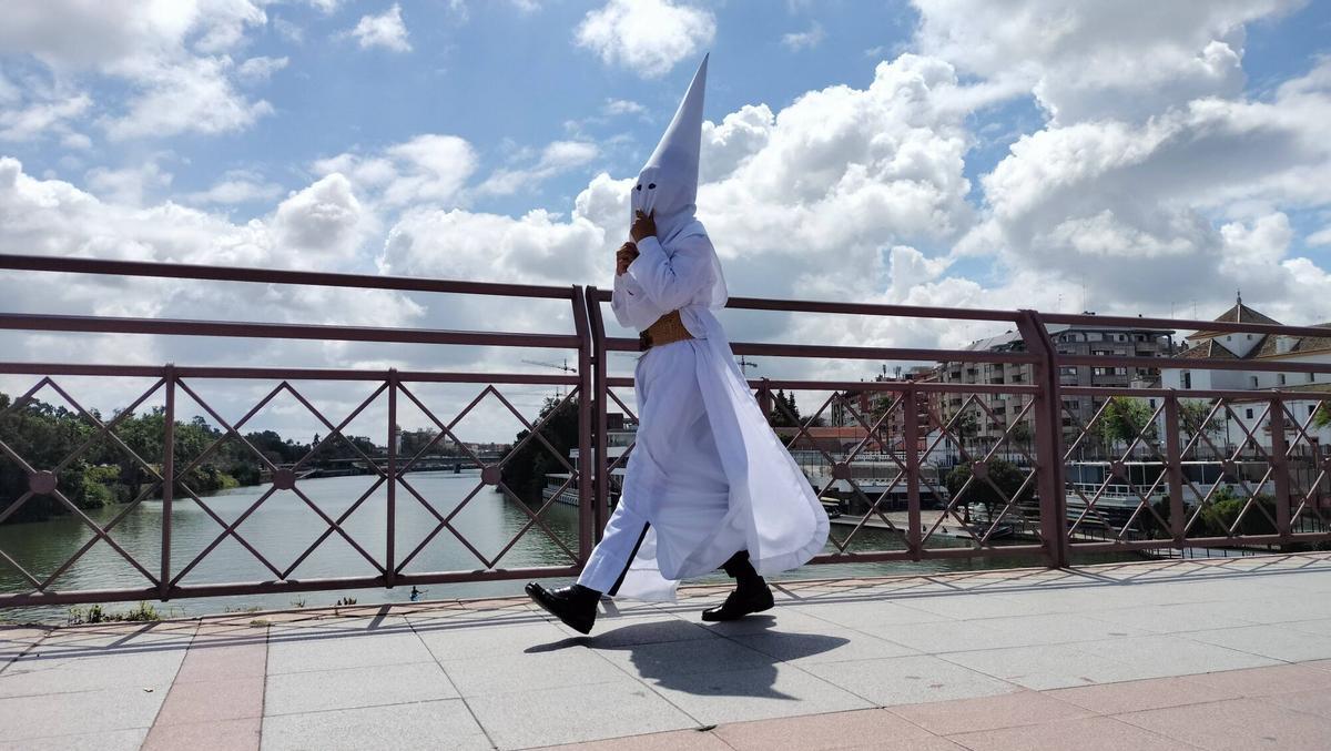 Nazareno de la Hermandad de la Borriquita por el Puente de San Telmo de Sevilla el Domingo de Ramos de 2025