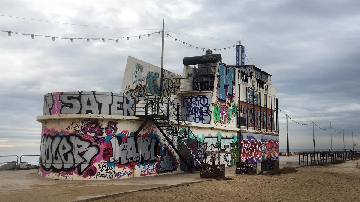 Viejo restaurante grafiteado con forma de barcosobre el espigón de Bac de Roda.