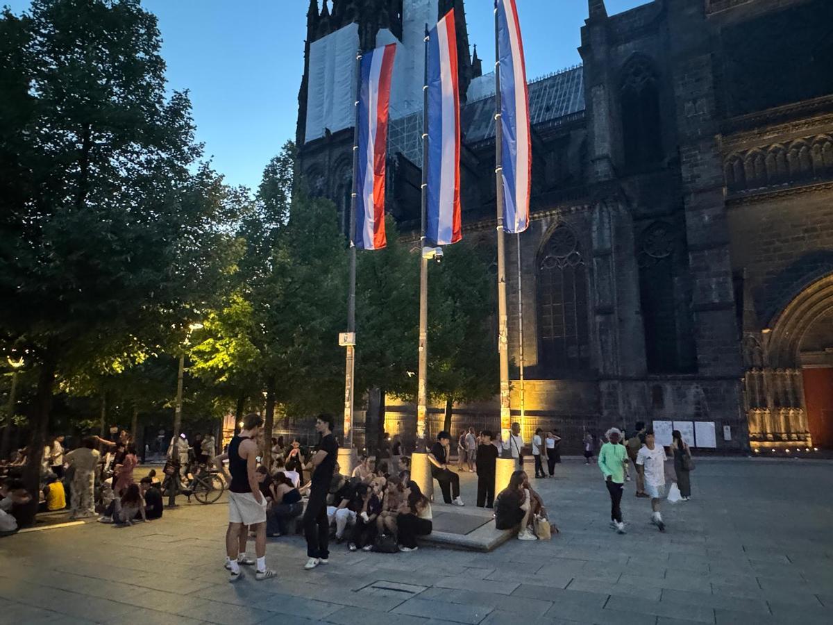Unos jóvenes se toman un respiro en una de las plazas de Clermont-Ferrand en el descanso del partido.