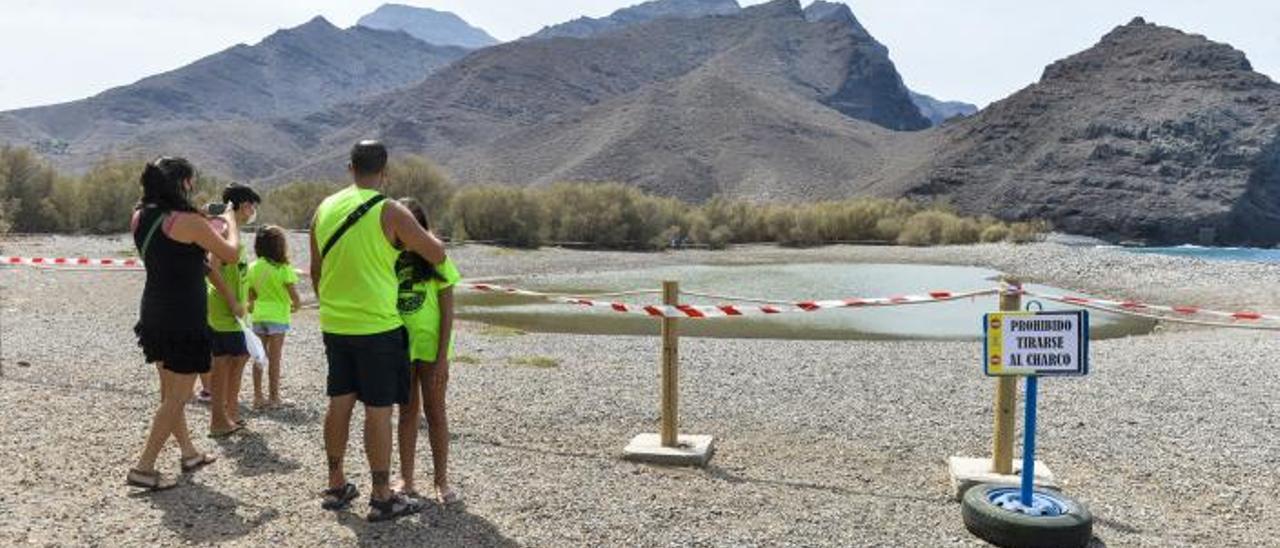 Una familia contempla El Charco de la playa de La Aldea el 11 de septiembre de 2020.