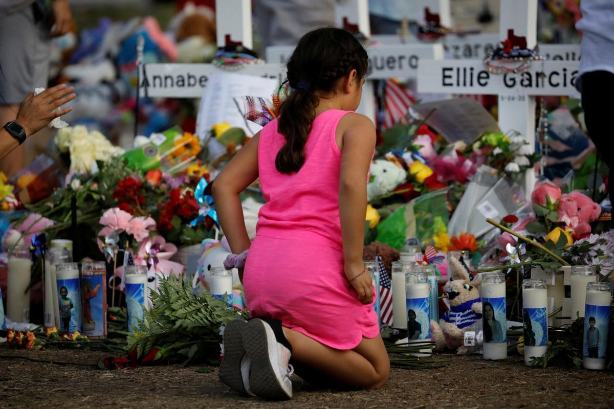 Una niña presenta sus respetos en el memorial de la escuela primaria Robb, donde un hombre armado mató a 19 niños y dos adultos, en Uvalde, Texas, EE. UU., el 28 de mayo de 2022. REUTERS/Marco Bello