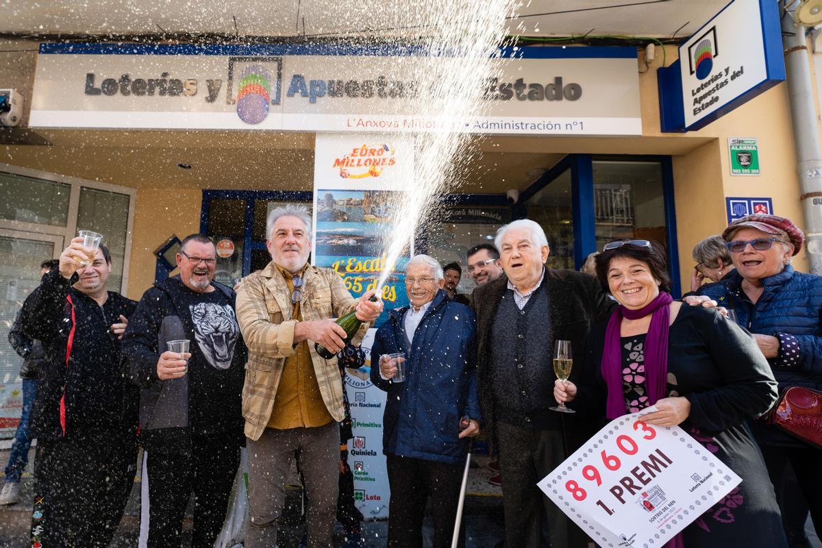 Los propietarios de la administración número 1 de L’Escala (Girona) celebran con agraciados y curiosos tras haber repartido todas las 40 series del primer premio de la Lotería de El Niño este viernes. La administración, que se llama l’Anxova Milionària, ha vendido todas las 40 series del primer premio de la Lotería del Niño 2023, con lo que ha repartido 80 millones de euros, todos en ventanilla. EFE/ David Borrat