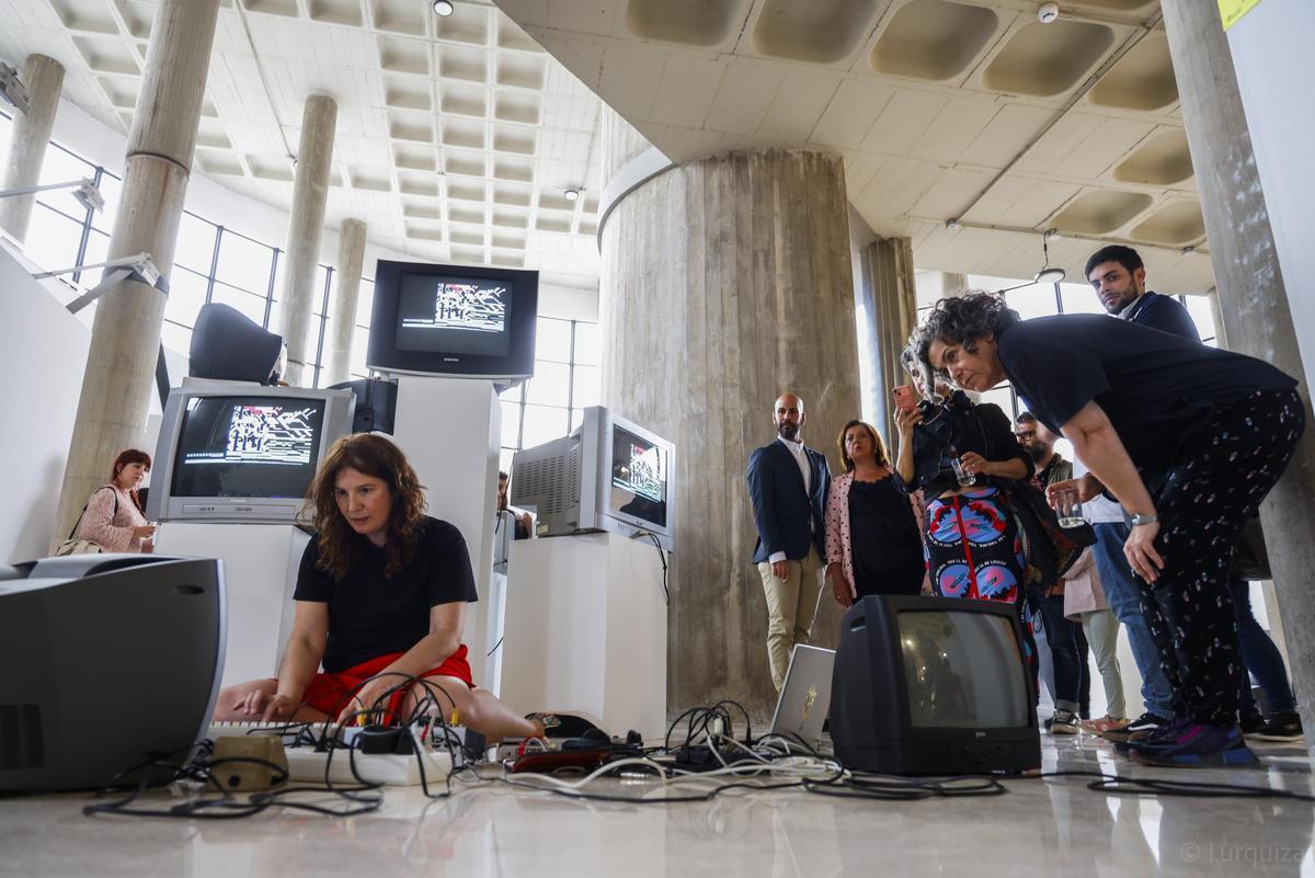 Raquel Meyers junto a visitantes y piezas de Estás obsoleta.