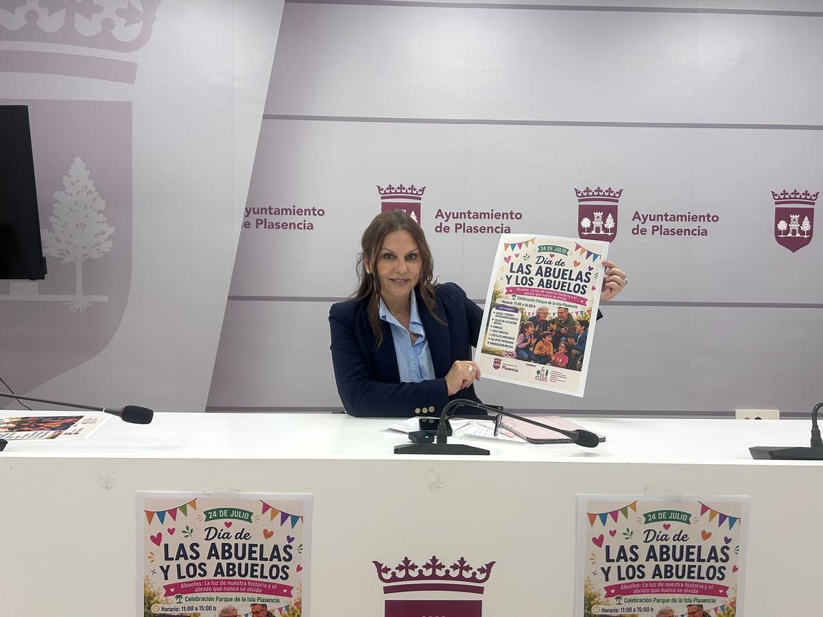 La concejala de Mayores de Plasencia, con el cartel de la actividad.