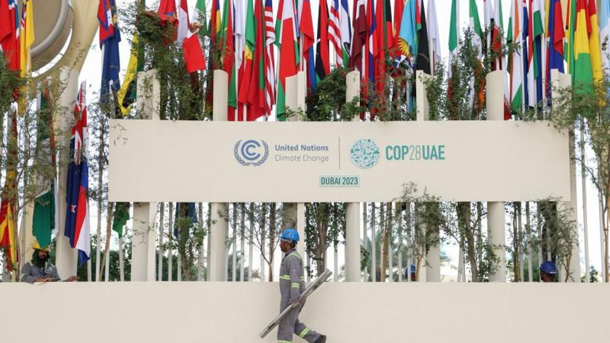 Un hombre camina frente a la sede de la cumbre del clima de Dubái.