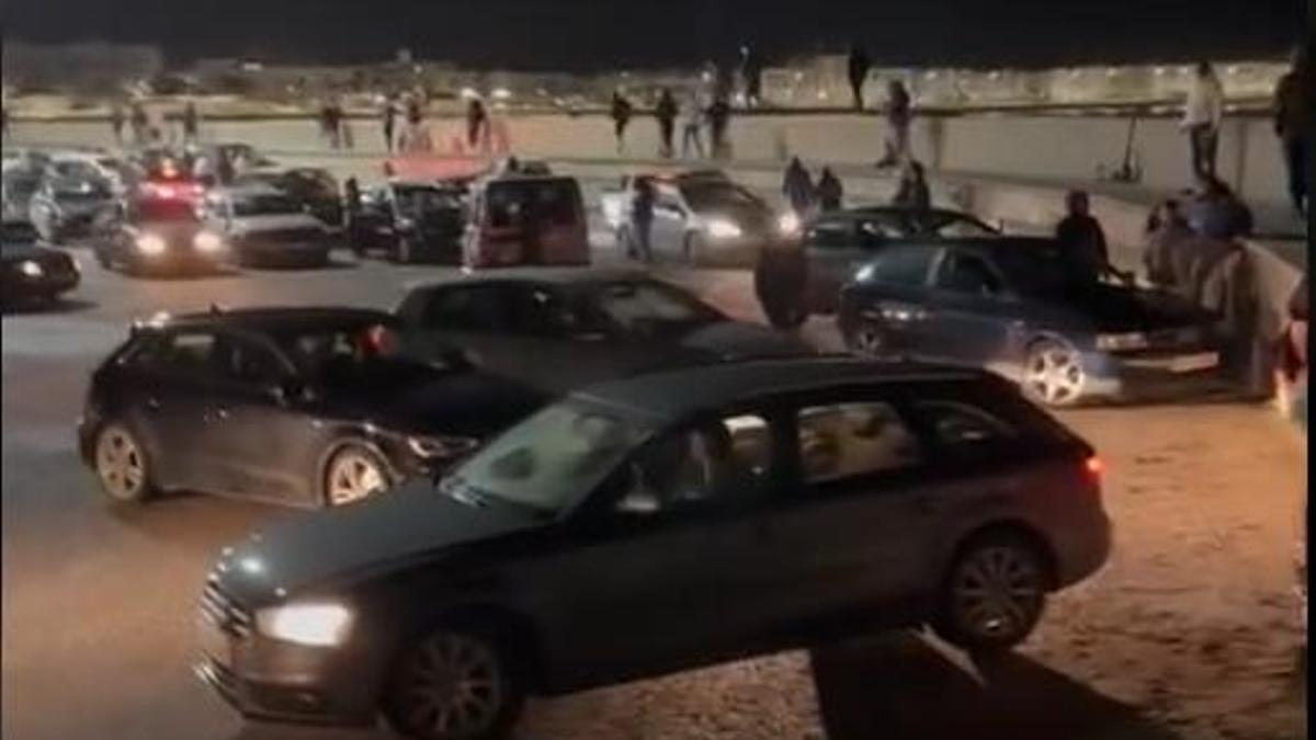 Un grupo de alborotadores, en el puerto de Barbate la noche del 9 de febrero, y ante un solo coche de la Guardia Civil