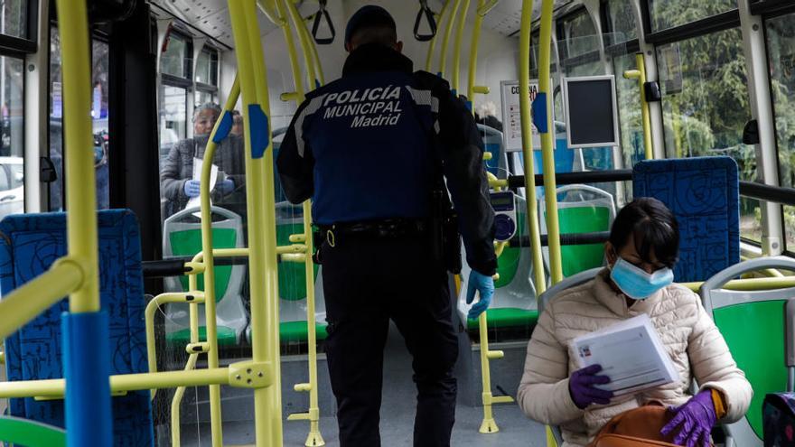 Un policia municipal de Madrid realitza un control als passatgers d&#039;un autobús urbà de la capital