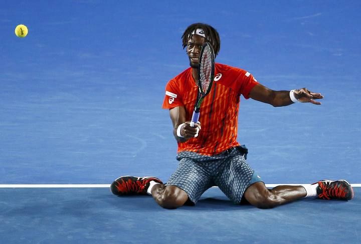 France's Monfils hits a shot on his knees during his quarter-final match against Canada's Raonic at the Australian Open tennis tournament at Melbourne Park