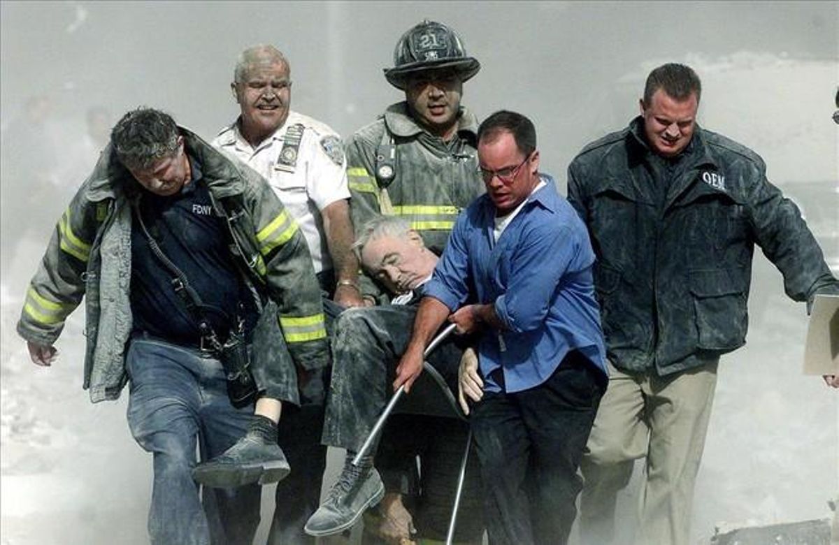 Rescue workers carry fatally injured New York City Fire Department Chaplain, Fether Mychal Judge, from one of the World Trade Center towers in New York, in this September 11, 2001.