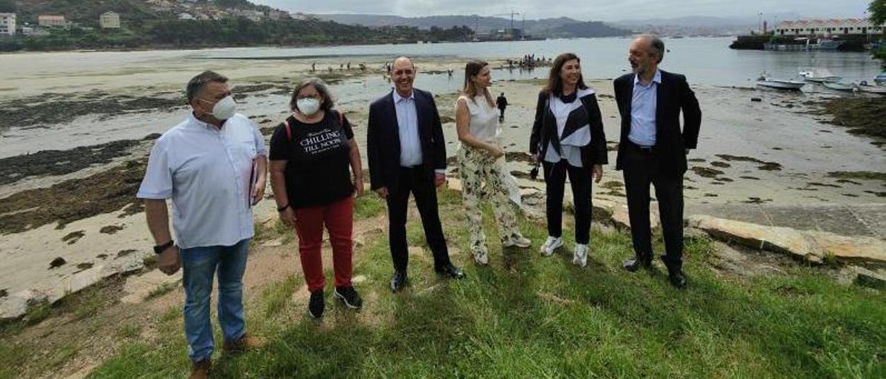 Luis Sequeiros, Dolores Álvarez, Manuel Pizarro, Cláudia Monteiro, Susana Rodríguez y José Millán Mon, en la ensenada de Meira, con las mariscadoras al fondo. |  SANTOS ÁLVAREZ