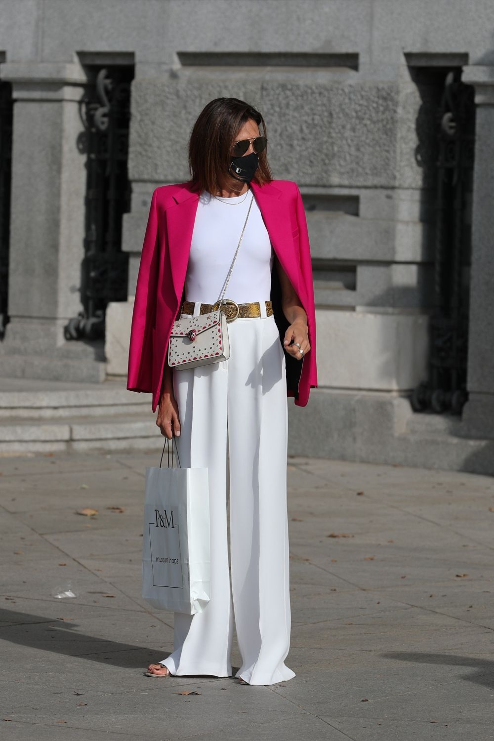 Nieves Álvarez con un elegante look que combina pantalones anchos y camiseta blanca a juego con unas sandalias y una americana fucsia
