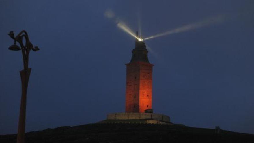 Torre de Hércules iluminada de rojo.