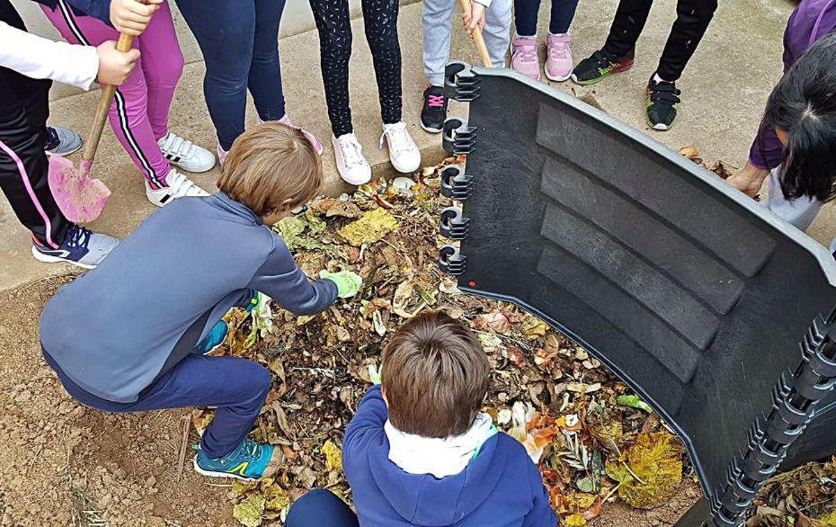 Escolares trabajando en el compostaje en su centro.