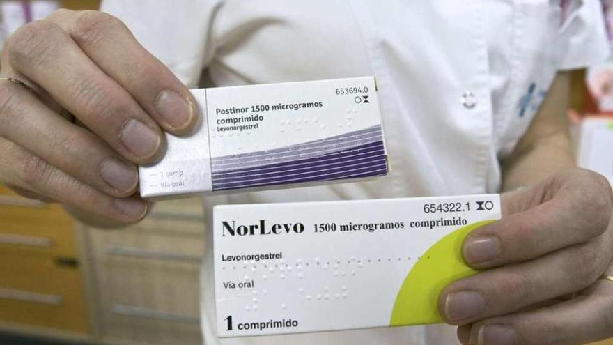 Un farmacéutico sostiene varios envases de la píldora postcoital.