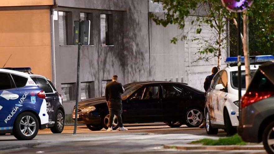 Policías nacionales introducen al detenido en el coche patrulla tras su detención.