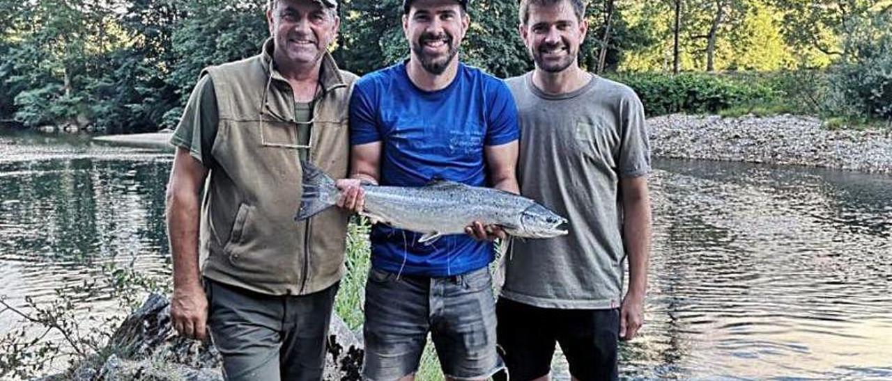 Cuco Mori, con sus hijos Efrén y Armando, con un salmón de tres kilos capturado el martes en el Sella.