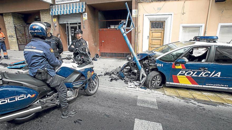 Varios agentes junto al vehículo policial accidentado.