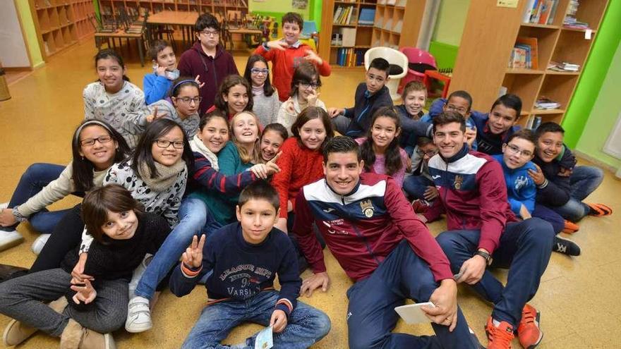 Adri Gómez y Javi Bonilla, con los niños del colegio de Barcelos. // Gustavo Santos