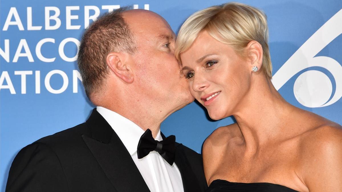 Monaco s Prince Albert (L) embraces Princess Charlene during the Monte-Carlo Gala for the Global Ocean in Monaco on September 28  2017    AFP PHOTO   YANN COATSALIOU