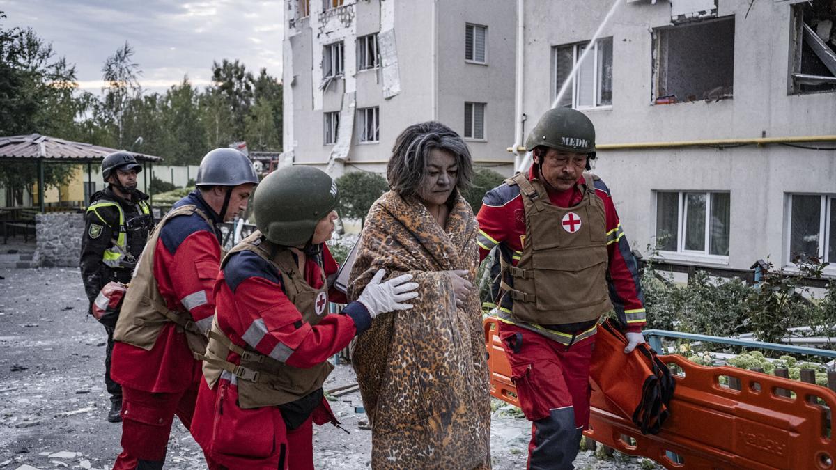 Los equipos de rescate ayudan a un civil herido a salir de un edificio residencial que ha sido alcanzado por un misil ruso.