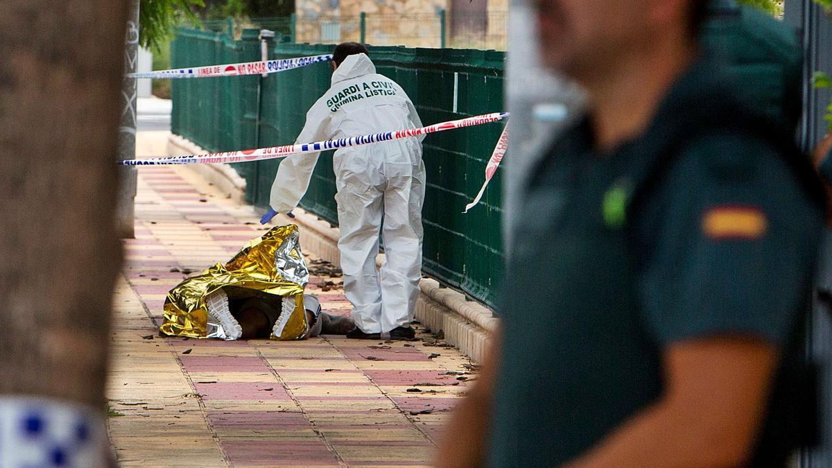 La Guardia Civil investiga en la escena del crimen, con el cadáver de la víctima cubierto. | JOSE NAVARRO