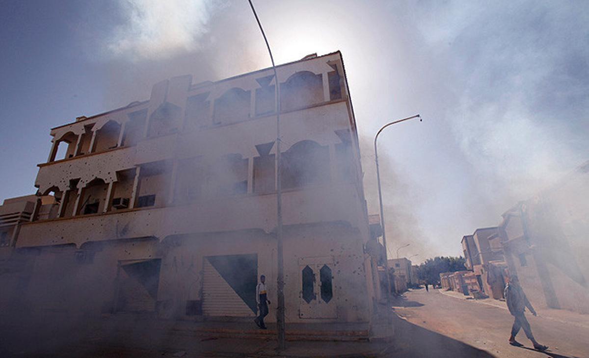 Un camió vaporitza fum per emmascarar l’olor dels cadàvers i rebutjar els insectes atrets per la pudor als carrers de Sirte, Líbia.