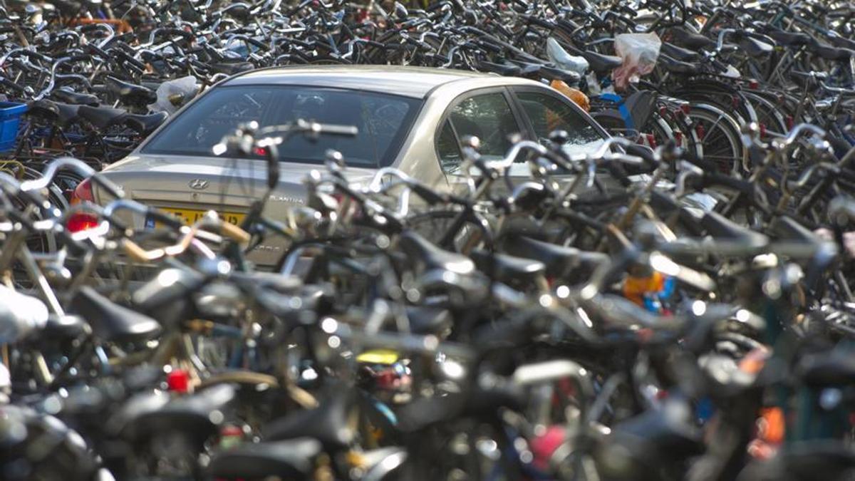 Un coche, casi sepultado por centenares de bicicleta, en la estación central de trenes de Amsterdam.