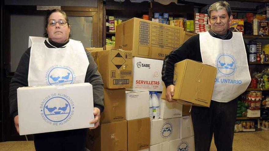 Dos voluntarios de O Mencer, con cajas de alimentos donados en el supermercado Gadis.  // Bernabé/J. Lalín
