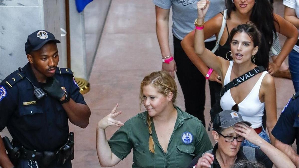 La comediante estadounidense Amy Schumer (centro) y la modelo estadounidense Emily Ratajkowski (derecha, detrás), en el momento de ser detenidas junto a otros manifestantes contra la elección de Kavanaugh.
