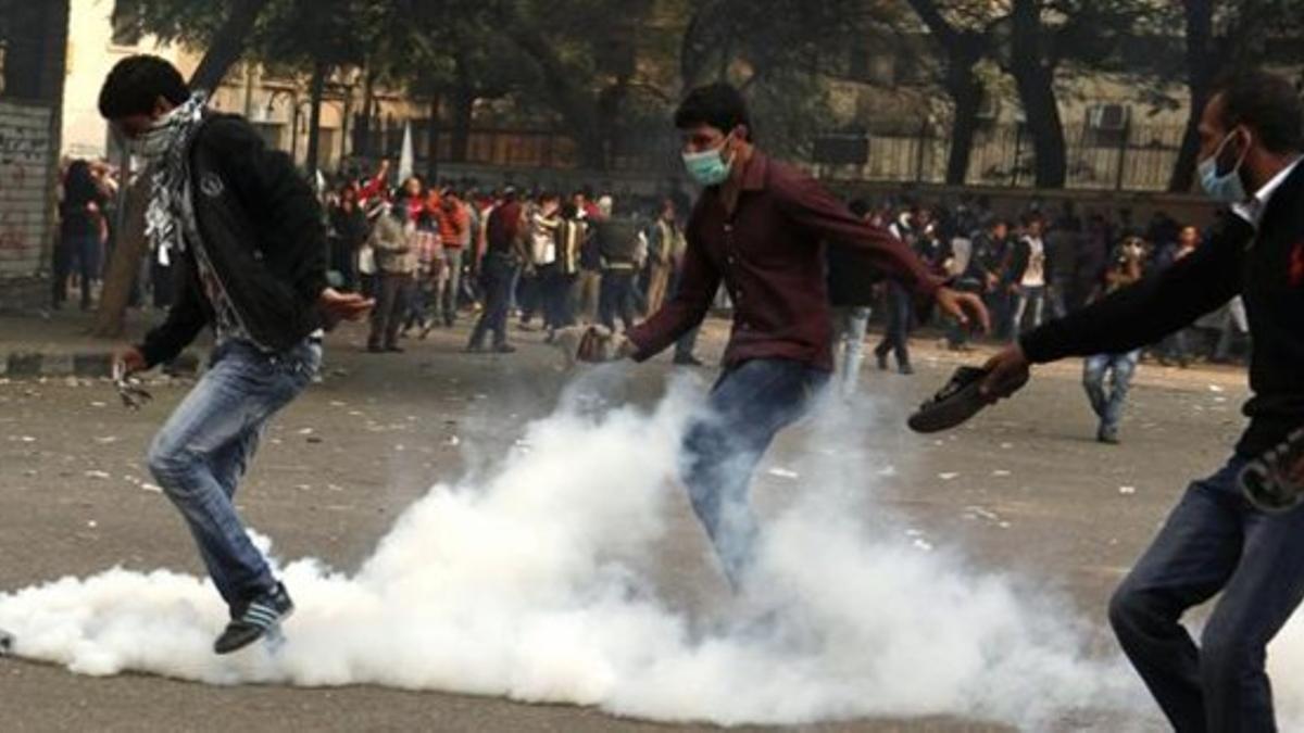 Manifestantes contrarios a Mursi en medio de gas lacrimógeno.