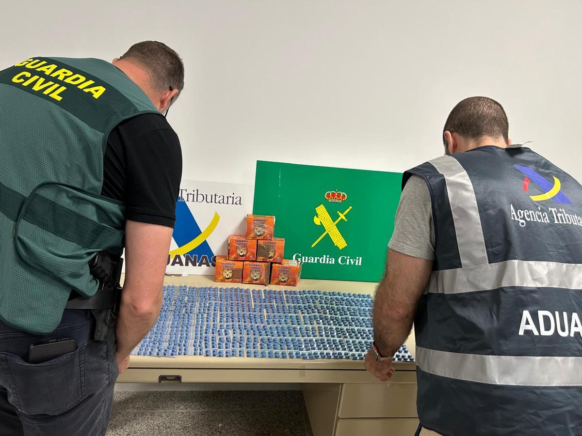 Dos agentes, con las pastillas incautadas.