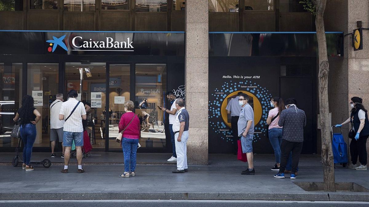 Cola de clientes antes una sucursal de Caixabank en Barcelona, el 26 de mayo
