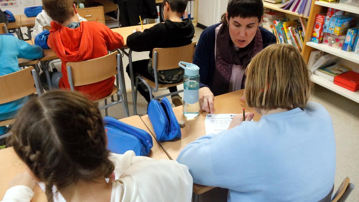 Una mestra atenent una alumna durant una classe d'anglès en una escola de les comarques gironines que ha rebut nens ucraïnesos