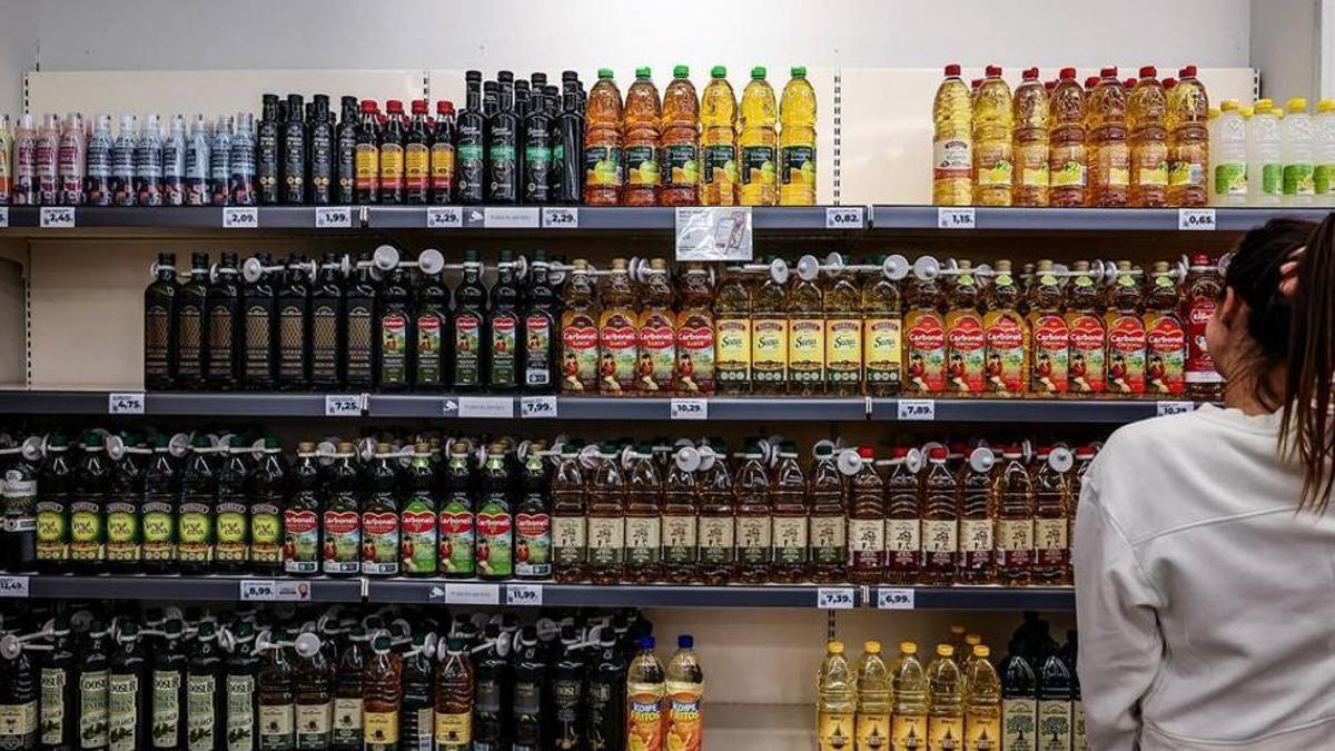 Una joven observa la estantería de los aceites en un supermercado. JORDI OTIX