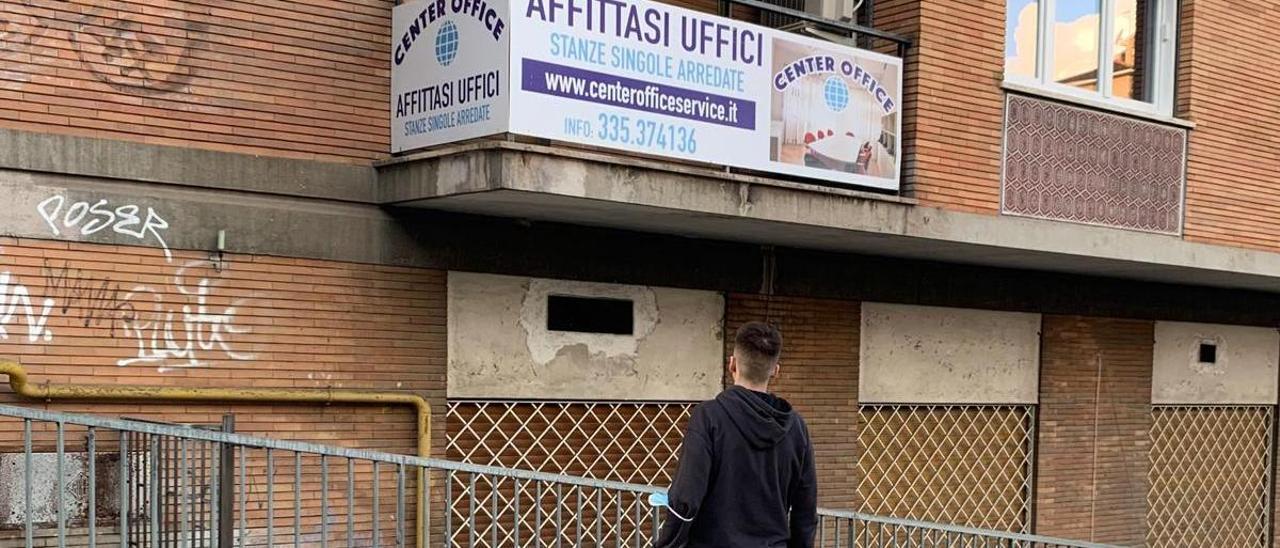 Mario, de espaldas a un anuncio de pisos en Roma.