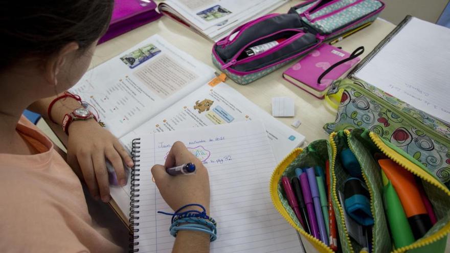 Una niña hace sus tareas escolares en un colegio de València.