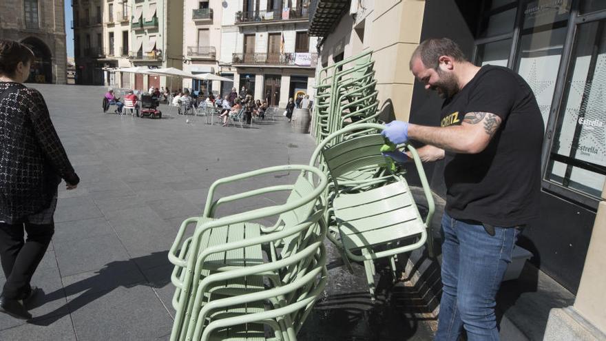 Palacios desinfectant les cadires del seu negoci