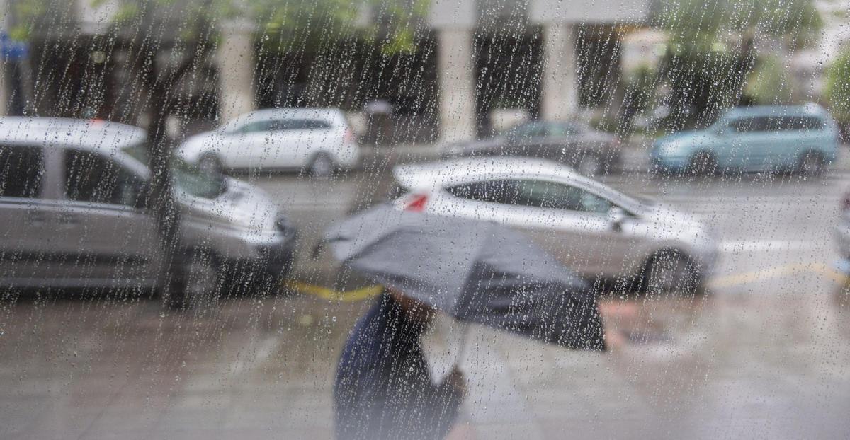 Un hombre con paraguas en Oviedo, que registra fuertes lluvias
