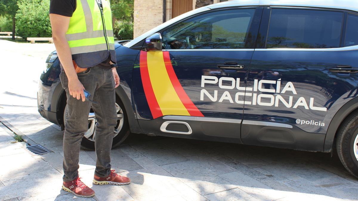 Un agente de la Policía Nacional junto a un vehículo