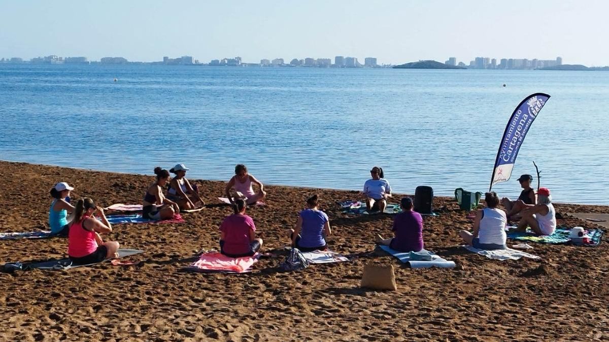 Un grupo de personas practicando deporte en la orilla del Mar Menor