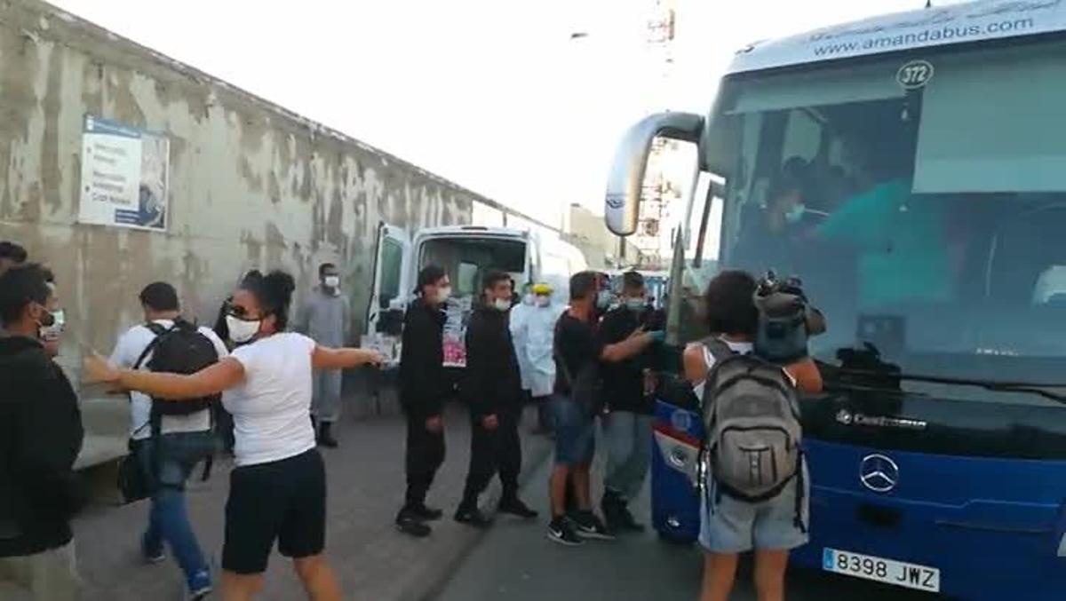 Los migrantes son trasladados en un autobús desde el muelle.