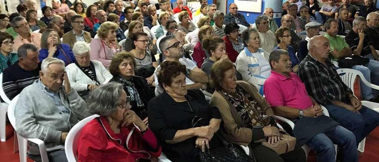 Los vecinos reunidos en el local del club Mecos para debatir con el alcalde sobre el PXOM. // Muñiz