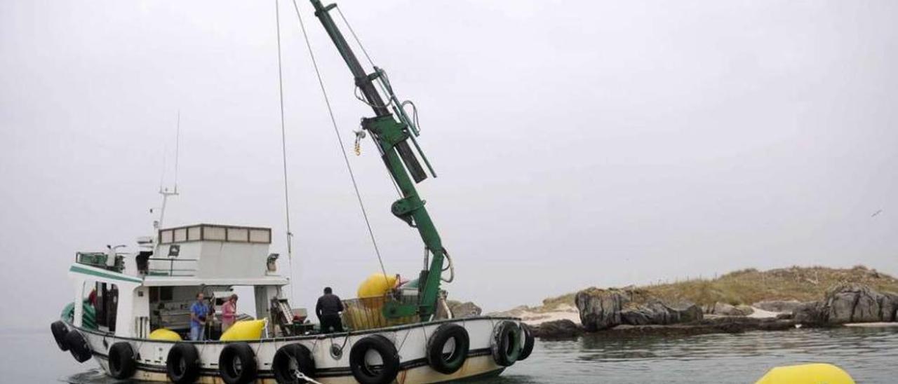 Instalación de las boyas en Areoso en el verano de 2015 por parte de la Cofradía de A Illa. // Noé Parga