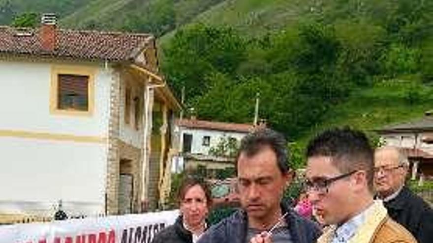 Ovidio Zapico y Alejandro Alonso, con la pancarta contra la carretera.