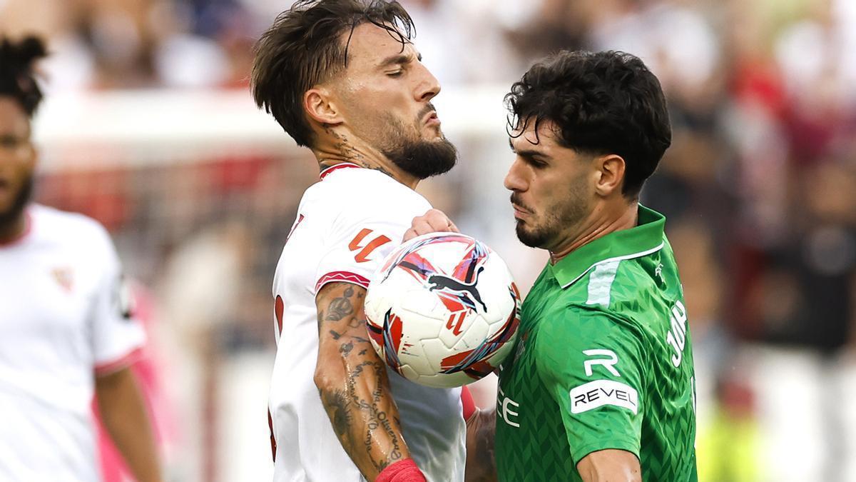 El centrocampista serbio del Sevilla Nemanja Gudelj (i) ante el centrocampista del Real BetisJoão Lucas de Souza (d).